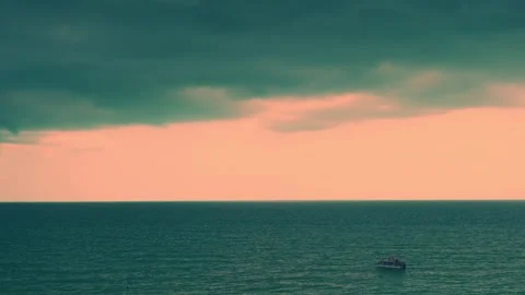 Thunderstorm Cumulus Clouds in an Orange Sky over the Sea and a Boat. An approac Stock Footage 319767391