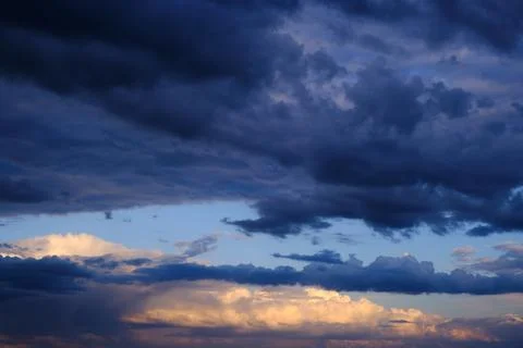 Thunderstorm dramatic clouds during evening sunset. Stock Photos