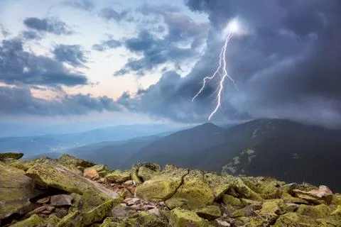 Thunderstorm with lightening and dramatic clouds in mountains Stock Photos