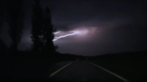 Thunderstorm lightning bolt striking over the traffic on a deserted highway at Stock Footage 115669310