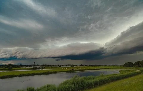 Thunderstorm with ominous looking shelf cloud over a river Stock Photos