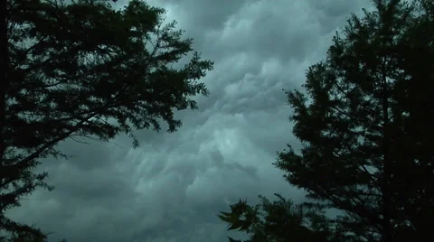 Thunderstorm, ominous, time lapse, framed by two trees in foreground Stock Footage 39413923