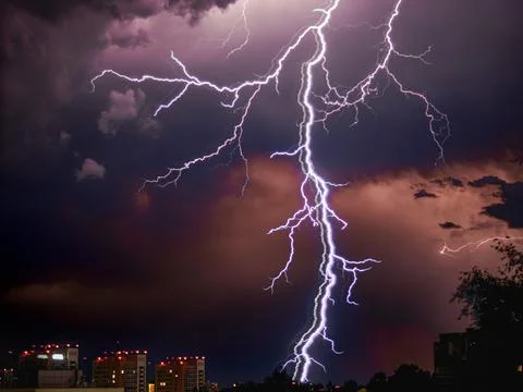 Thunderstorm. Thick lightning on the night sky background. Electrical storm in Stock Photos