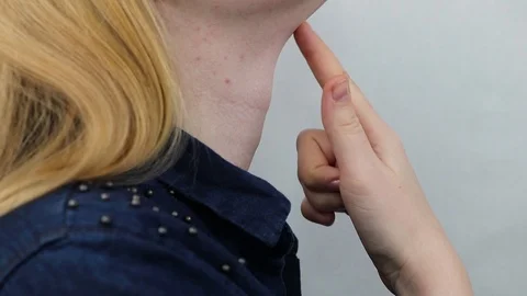 Thyroid gland. Closeup portrait of cute sick young blonde woman in white top hav Stock Footage 88133834