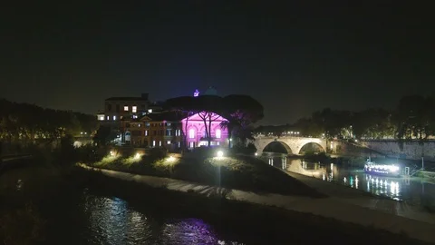 The Tiber Island by night with a light that colors the house, the side bridge an Stock Footage