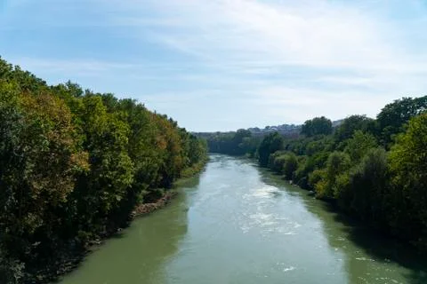The Tiber river flows along with trees in sunny day, Rome, Italy. Stockfoto's