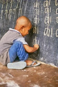 Tibetan boy writing Tibetan script on blackboard, Himachal Pradesh, India,... Stockfoto's