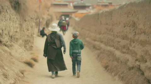 Tibetan Buddhist pilgrims circumambulate Labrang Monastery, Xiahe, China Stock Footage 55769334
