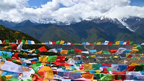 Tibetan buddhist prayer flags blowing in the wind with Meili snow mountain Stock Footage 118917153