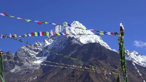 Tibetan prayer flags against white snowy mountain peak Stockbeeldmateriaal 74454983