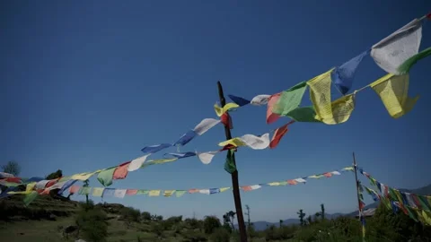 Tibetan prayer flags stretched across a wooden pole waving in strong wind over Vídeos de archivo 343141244