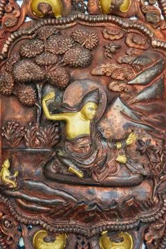 Tibetian monk is doing practice. Copper bas-relief on the door to Monastery Ilustración de archivo