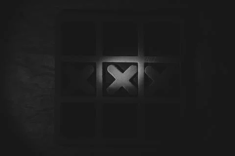 Tic-tac-toe on a dark background with dramatic lighting. Tabletop game, tac.. Stock Photos