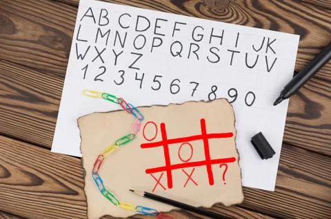 Tic-tac-toe drawing on old paper near handwriting alphabet and chain Stock Photos