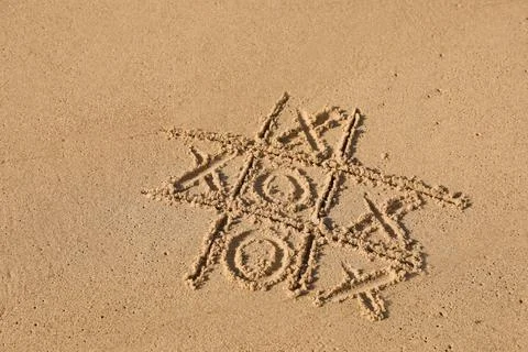 Tic tac toe game drawn on sandy beach Stock Photos