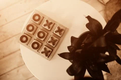 Tic-tac-toe game in stone box on the table for family play in free time Stock Photos