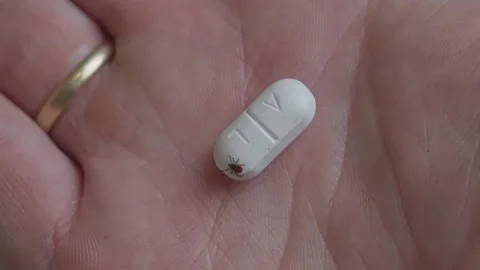 Tick crawling on antibiotic tablet symbolizing infection and medical treatment 스톡 동영상 319623064