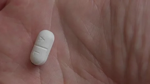 Tick crawls across human hand onto antibiotic pill symbolizing infection and 스톡 동영상 319623075