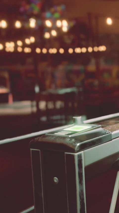 Ticket machine sits in a busy area with bright lights at night Stock Footage 339774474