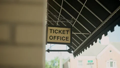 Ticket office and booth signage hanging from canopy outside front Stock Footage 249342181