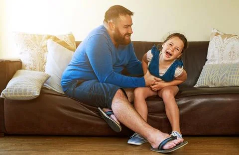 Tickled with glee. an adorable little girl getting tickled by her father at home Stock Photos