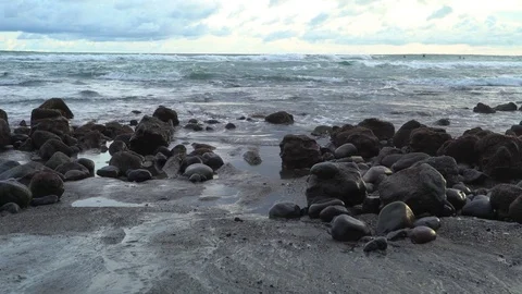 Tidal rocks on the beach with waves crashing behind them Stock Footage 74290434