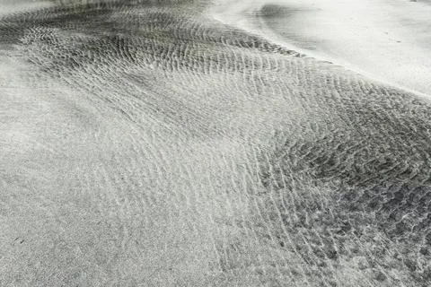 Tidal sorting of white sand and darker minerals into patterns at the west coast Stock Photos