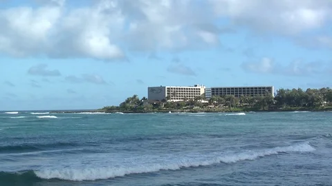 Tide pulls waves into shore at beach oceanside hotel Stock Footage 125340972
