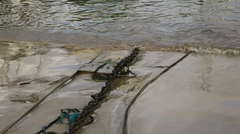 Tide washing in over rusty chains Stock Footage 33986884