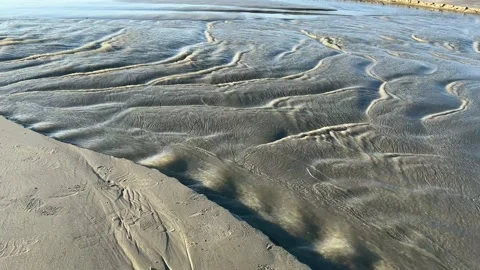 Tide water moving quickly over the sand creating beautiful natural ripples Stock Footage 231083870