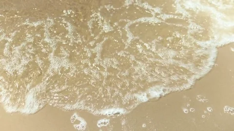 Tidewash Loop. Sea tide washes up a sandy shore and out again. Loop-able clip Stock Footage 76196360