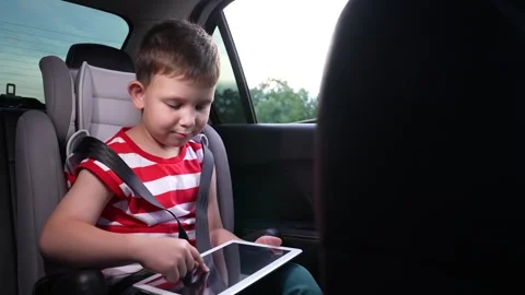 Tidy car interior, Child absorbed in device, Family vehicle, Summer vacation Stock Footage 315529995