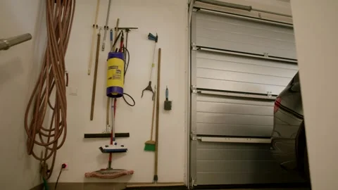 Tidy Garage with Cleaning Tools on Wall and Parked Car, Slow Pan Interior Stock Footage 341566955