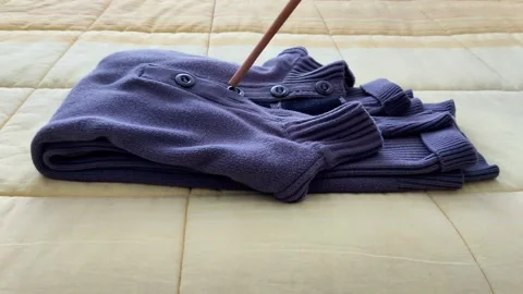 Tidy Gray Sweater Placement on Neutral Quilted Fabric Surface Stock Footage 322509949