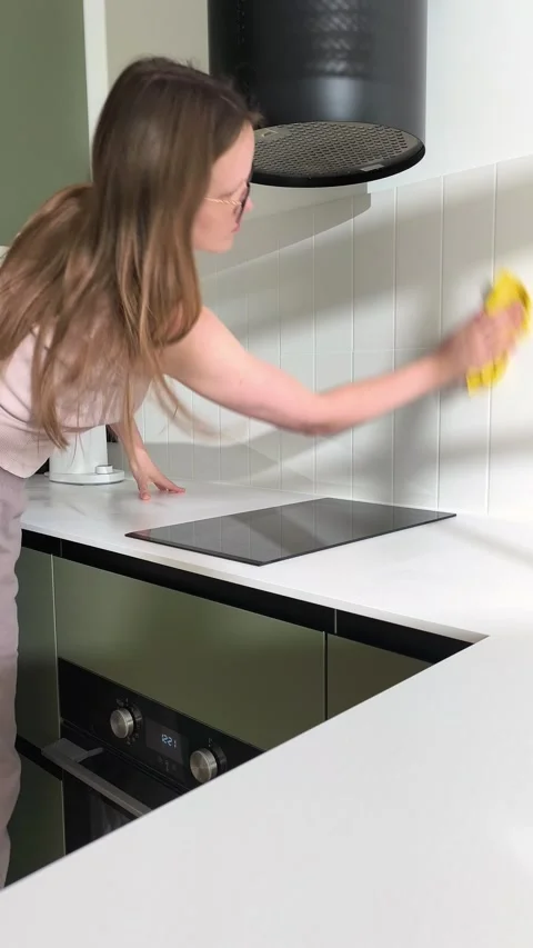 Tidying modern kitchen interior with tile backsplash cleaning actions. Woma.. Stock Footage 345553076