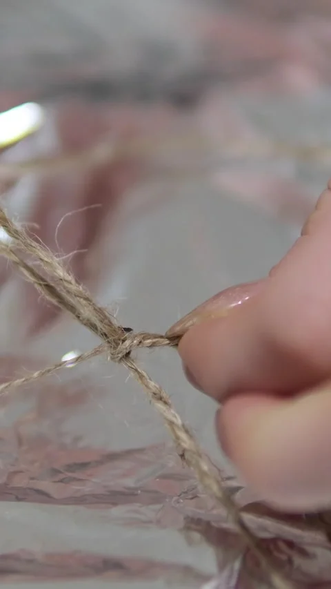 Tie string rope on foil open gift open pizza delivery unpacking Woman, bow or Stock Footage 303487710