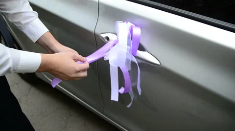 Tie wedding decorations to the handle of the car 動画素材 49340098