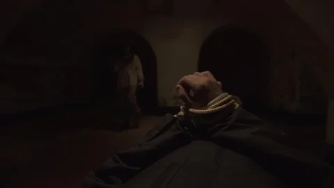 Tied man lying on altar trying to free while ghost with knife approaching. POV Stock Footage 245578294