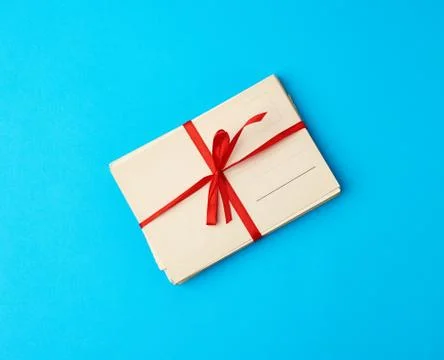 Tied red silk ribbon rectangular vintage greeting card, blue background 写真素材