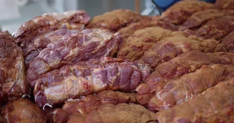 Tied roasts covered with a spice crust lying close together in a butcher 動画素材 339990702