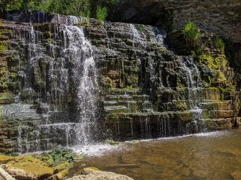 Tiered Limestone Waterfall Cascading down Mossy Rocks Into Shallow Pool Stock Photos