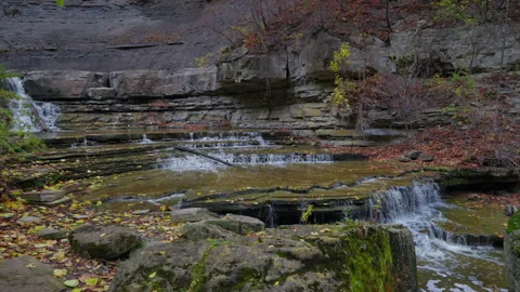Tiered Limestone Waterfall Cascading over Bedrock Ledges in Autumn Woods 스톡 동영상 348242919