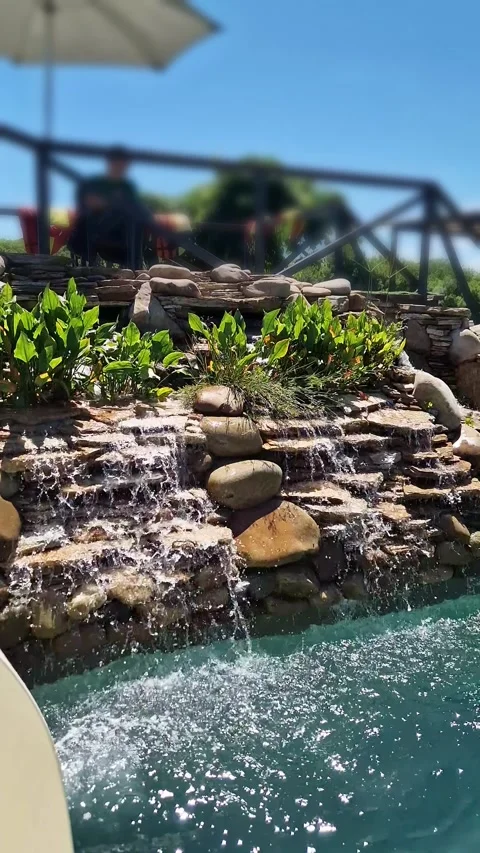 Tiered Stone Waterfall Cascading Into Turquoise Swimming Pool Water Stock Footage 339085763