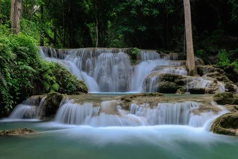 Tiered Waterfall Flows Through Lush Tropical Rainforest In Thailand Wide Shot Foto stock