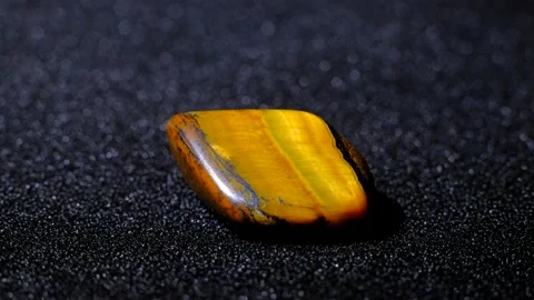 Tiger's Eye flat gemstone rotating on a black background. Stock Footage 162443965