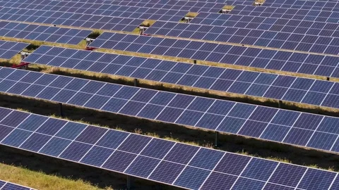 Tight aerial pull pan over solar array rows of panels Stock Footage 293429231