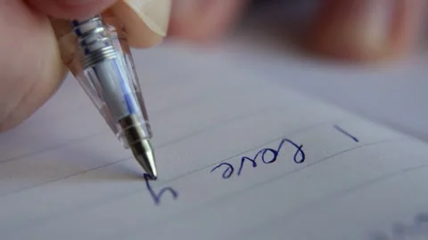 A tight close up captures a female hand writing the same words I love you in a Video stock 324839082