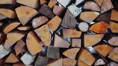 Tight close-up side view of split firewood stacked with snow in a rustic shed Stock Footage 327554213