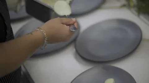 A Tight of female adding desert over plates on table Stock Footage 155465607