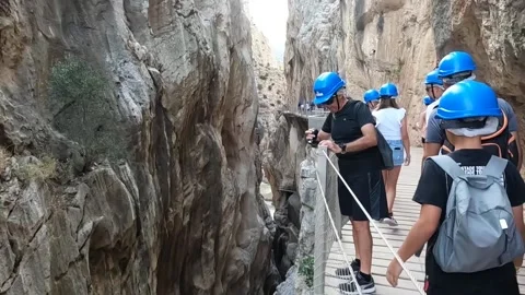 Tight gap between gorge, tourists on pathway Caminito del Rey Video stock 220741666